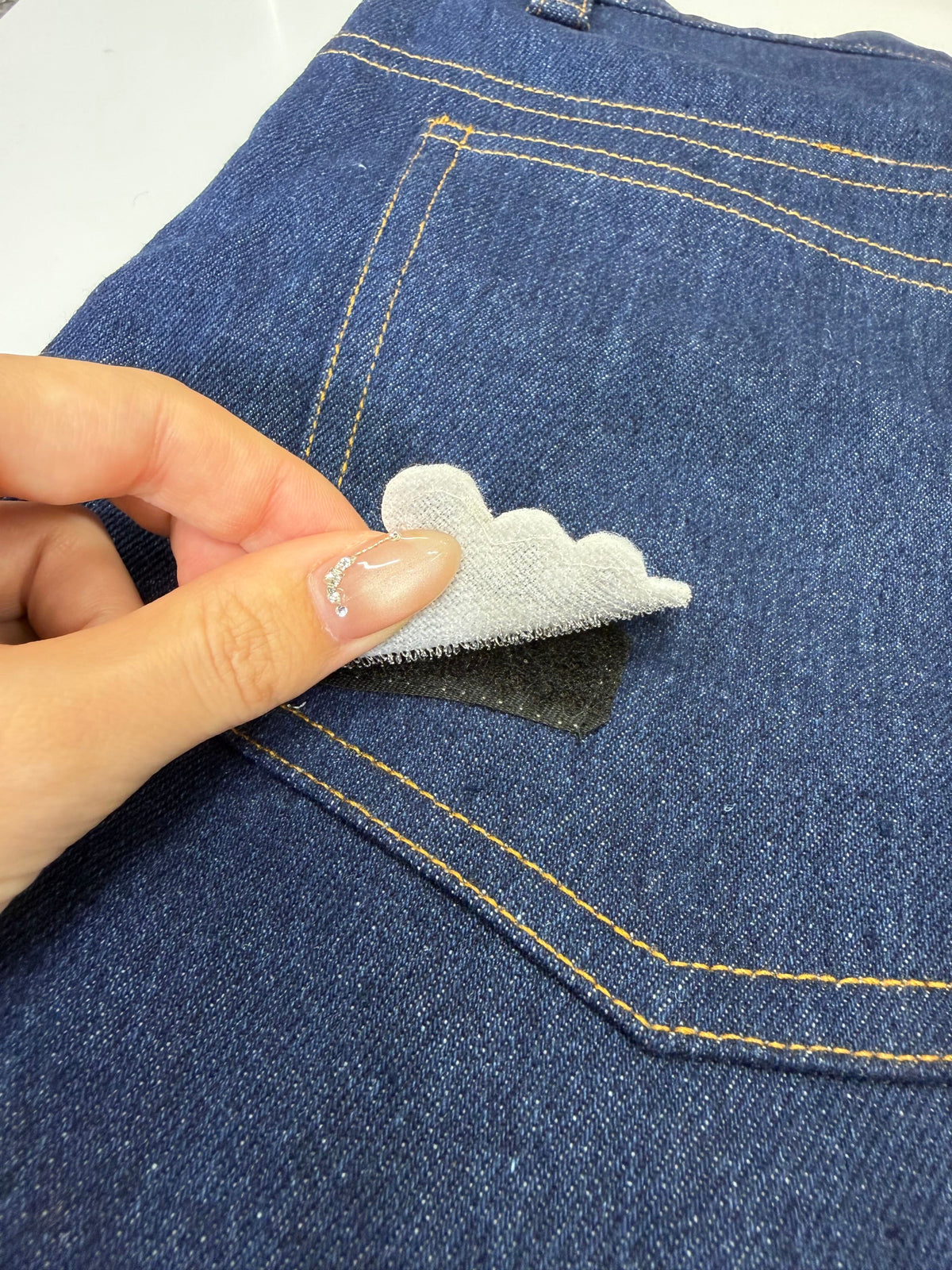 マジックテープ式のワッペンを取り外す様子（ネイビー）